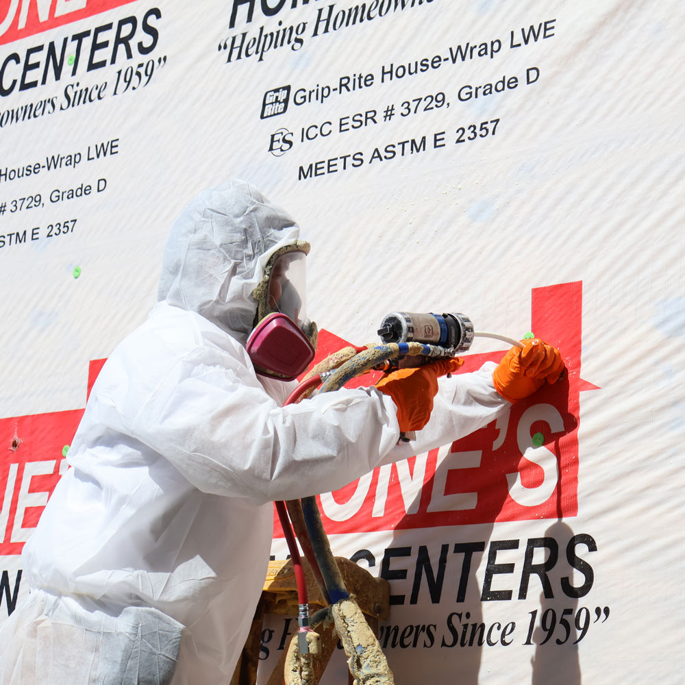 professional installing injection foam insulation to exterior of building