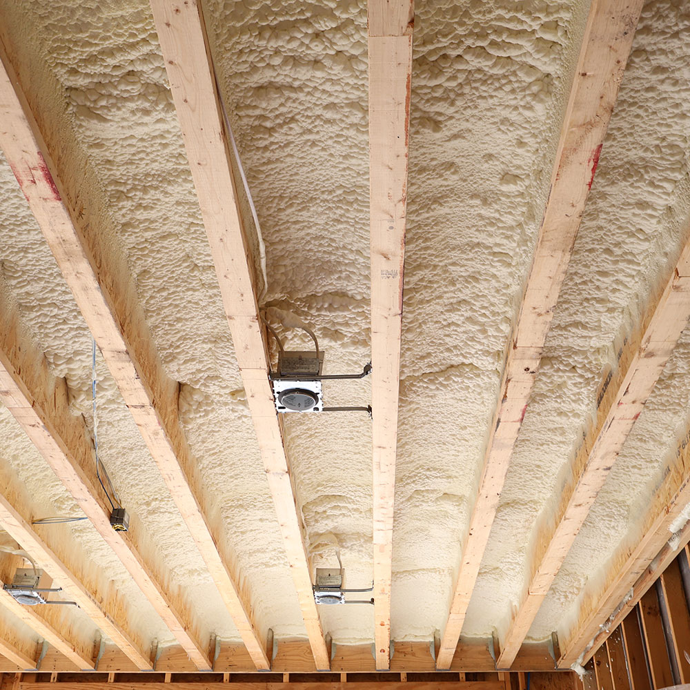 Ceiling view of wooden beams filled with spray foam insulation