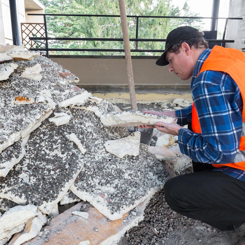 Technician examining removed insulation material during cleanup process