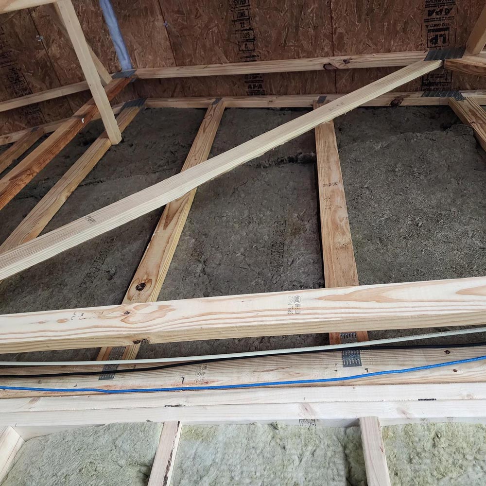 mineral-wool-attic-roofline-insulation Mineral wool insulation installed along attic roofline between rafters