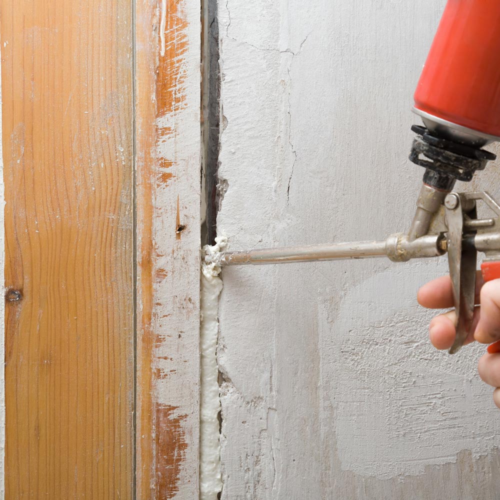 Spray foam insulation applied to seal gaps around a door frame