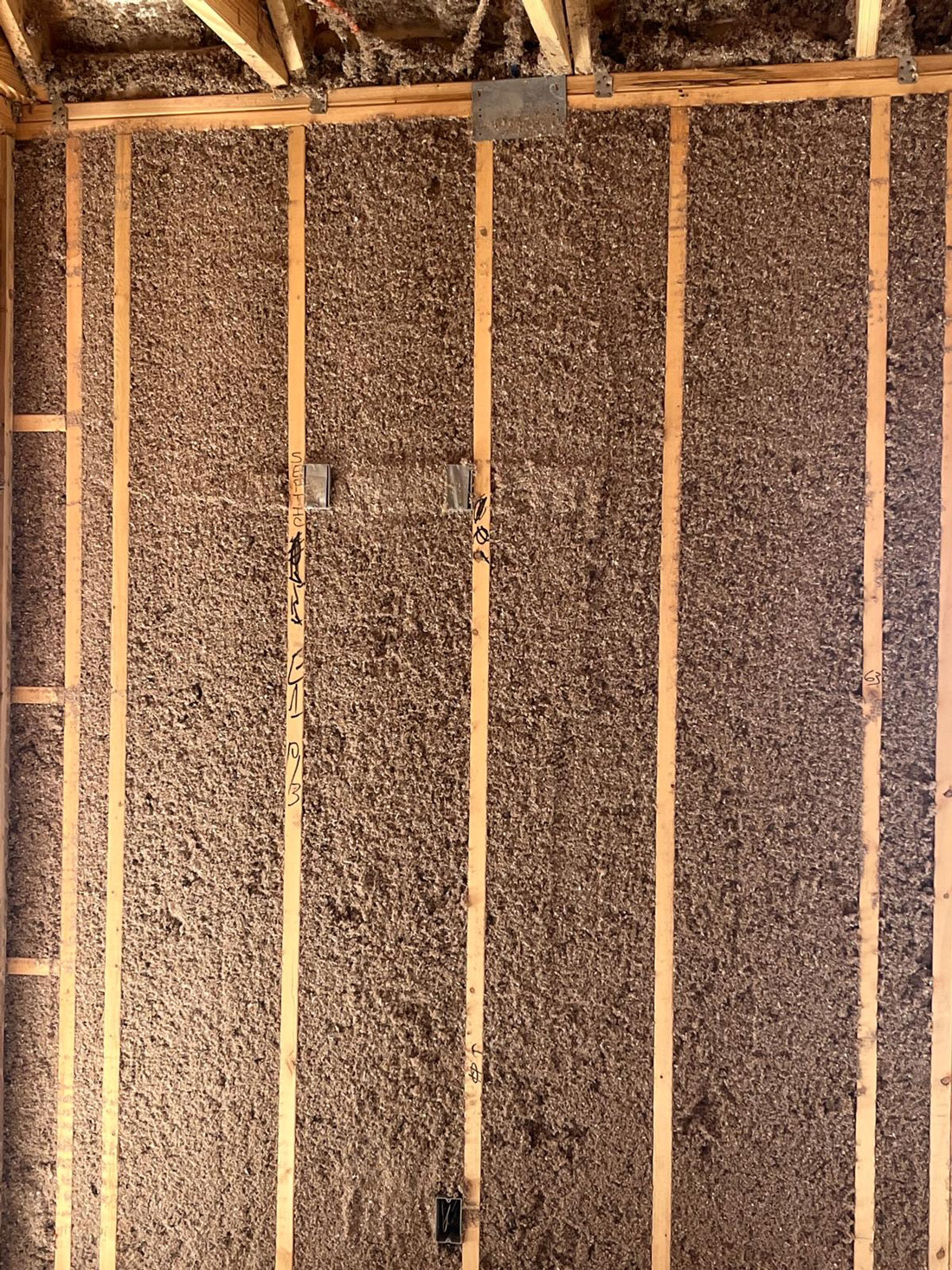 cellulose-wall-spray-1 Dense-pack cellulose insulation installed in wall cavities to improve energy efficiency, sound control, and year-round comfort.