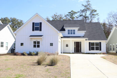 Newly constructed single-family home in South Georgia with white board-and-batten siding and black roof.