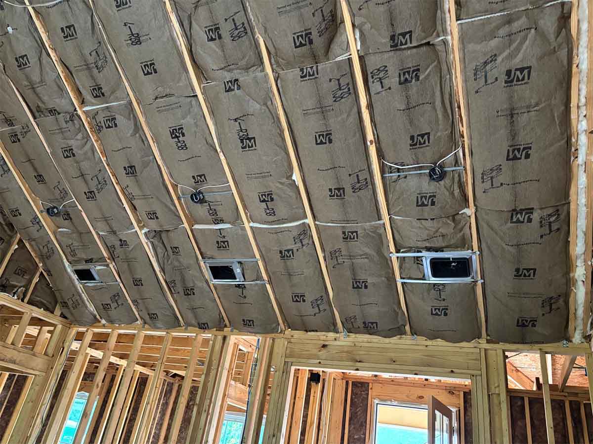 Quality Insulation of Valdosta installed kraft-faced R-38 fiberglass batts around recessed light and HVAC boxes in a vaulted ceiling in Hahira, GA.