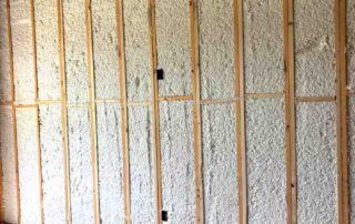 Quality Insulation of Valdosta sprayed Johns Manville Spider Plus into full-height exterior wall cavities, with Owens Corning Rim Seal along the top plate and kraft-faced batts in the vaulted ceiling above, in a new home.