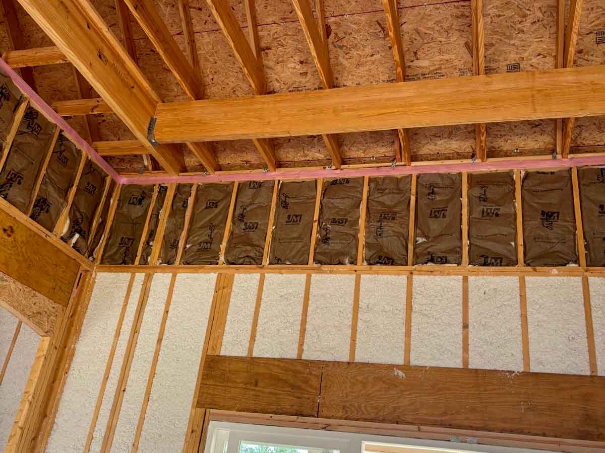 Quality Insulation of Valdosta sprayed Johns Manville Spider Plus into exterior wall cavities, with kraft-faced batts in the upper wall and Owens Corning Rim Seal along the top plate, in a new home.